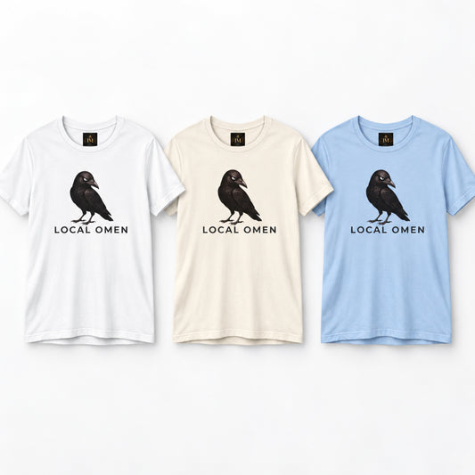 White, cream and light blue Local Omen T-shirts with black raven graphics, shown side by side
