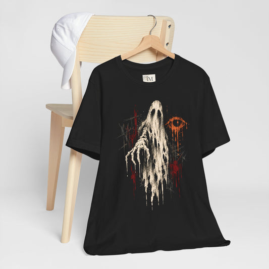 Black Ghost Drip T-shirt on a hanger in front of a wooden chair, showing a cream ghost and orange eye graphic