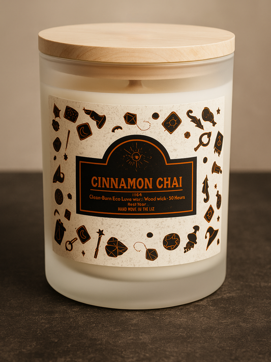 Cinnamon Chai frosted glass wood wick candle with eco luxe clean-burn wax, wooden lid, and Halloween-themed black icon pattern label. Hand-poured Invaluable Minutia exclusive.