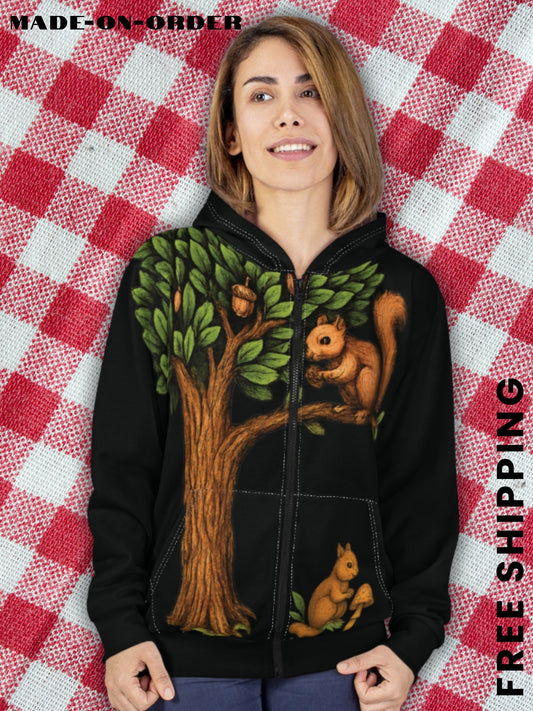 Woman wearing a black zip-up hoodie with a woodland squirrel and tree design, standing against a red and white checkered backdrop. Boutique fall fashion with free shipping.